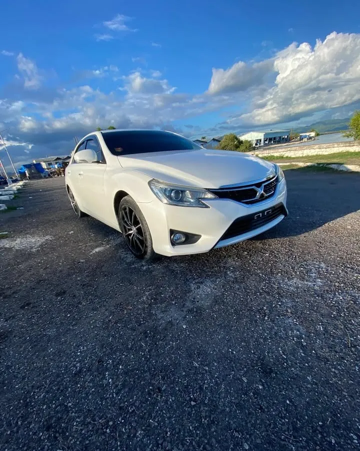 White Toyota Mark X under a blue Jamaican sky